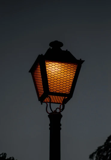 an old fashioned street lamp in front of a night sky