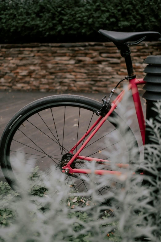 a red bike that is parked in front of a wall