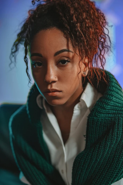 a young woman in a green cardigan is staring at the camera