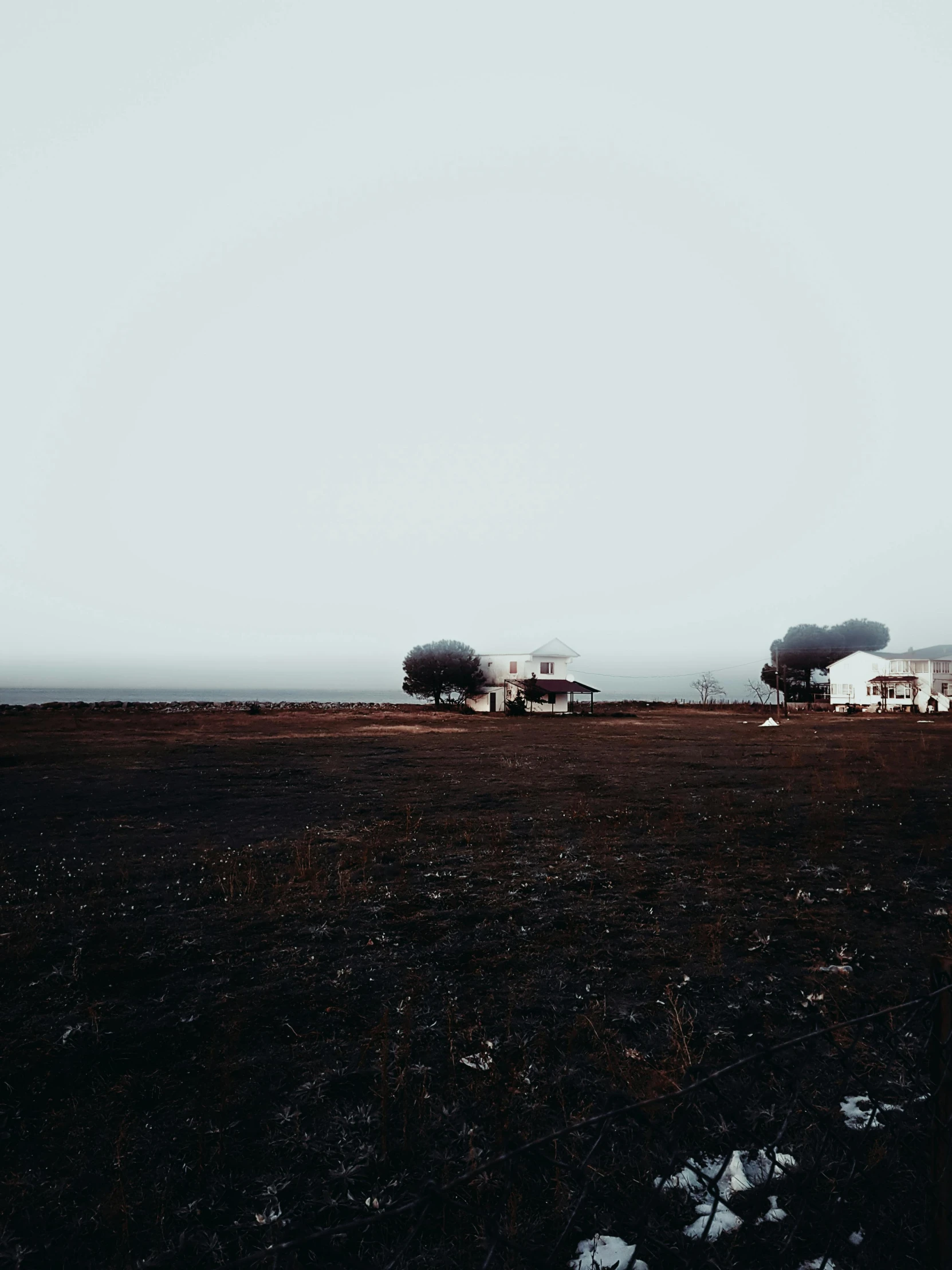 a black field with two tankers and white buildings