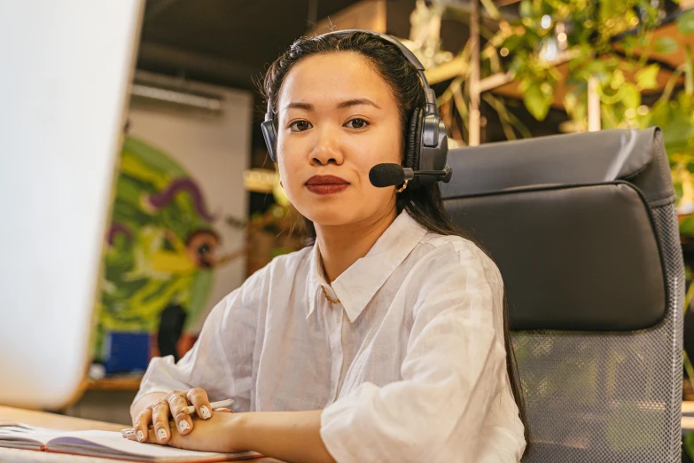 a woman is working at a desk with her headset on