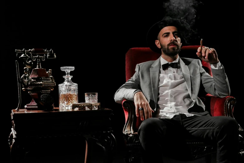 a man in a tuxedo is smoking a cigarette in a chair