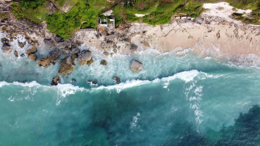 an aerial view of the ocean waves with the cliffs