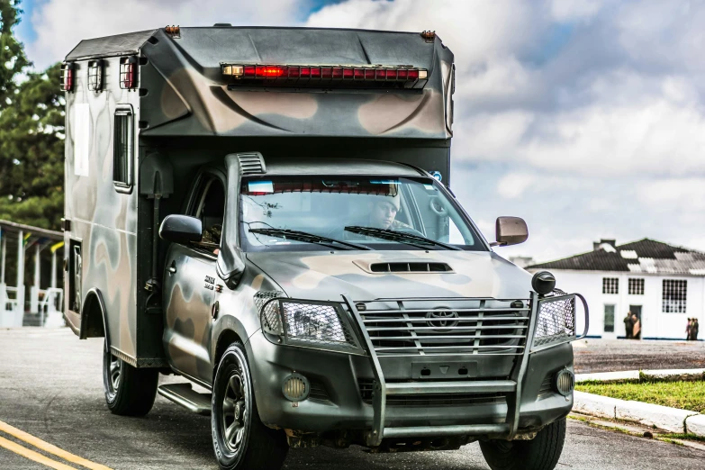 a gray motor home sitting on the side of a road