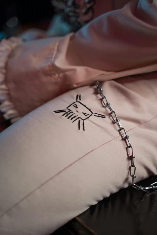 a person with their foot on a pillow with chains on it