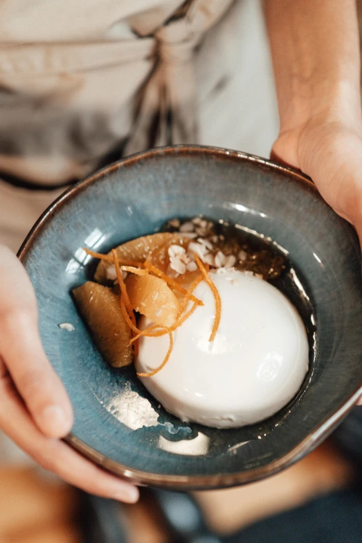 person holding a bowl with some food in it