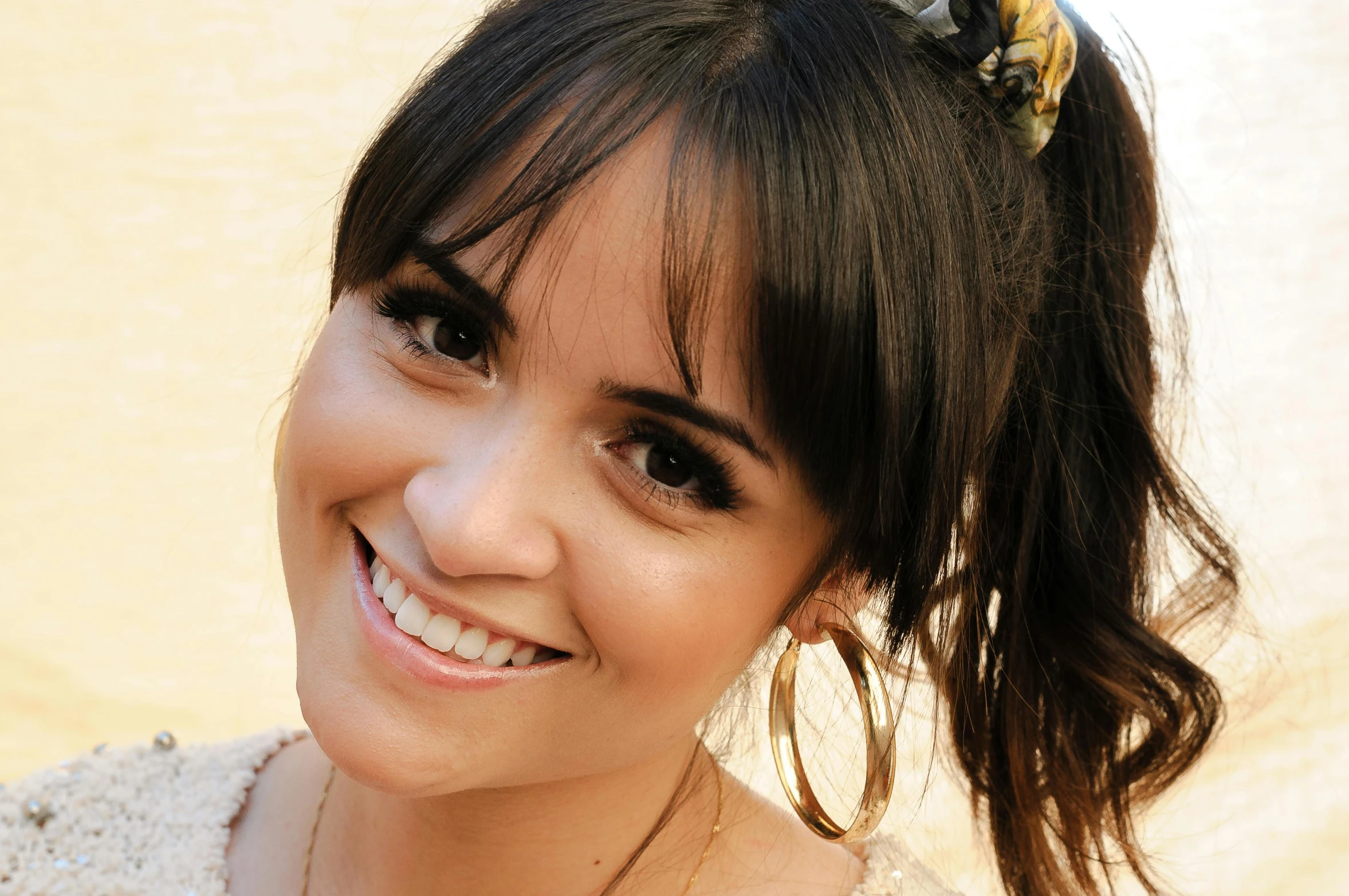 a woman with a necklace is smiling at the camera