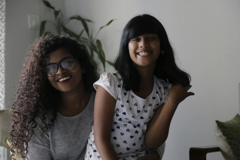 two girls smile brightly while holding hands