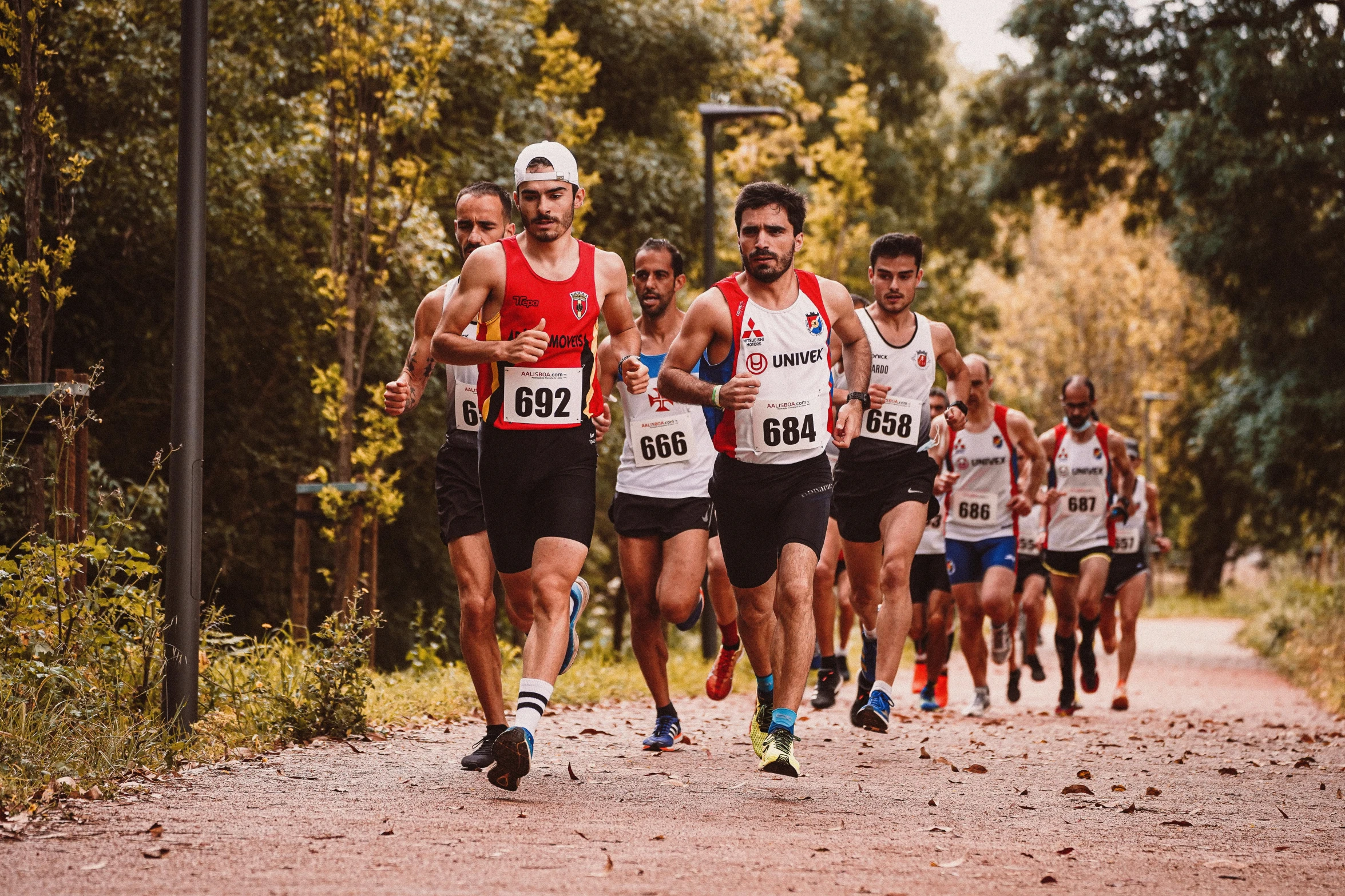 a group of men are racing along a dirt road