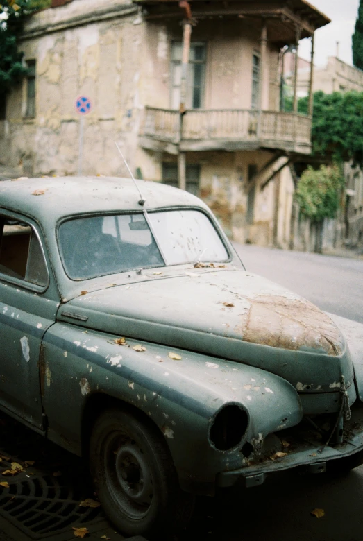 an old car that has been rusted sitting outside