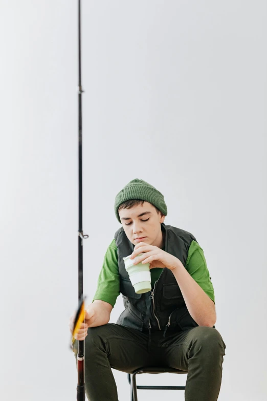 a boy sitting on a chair while drinking coffee