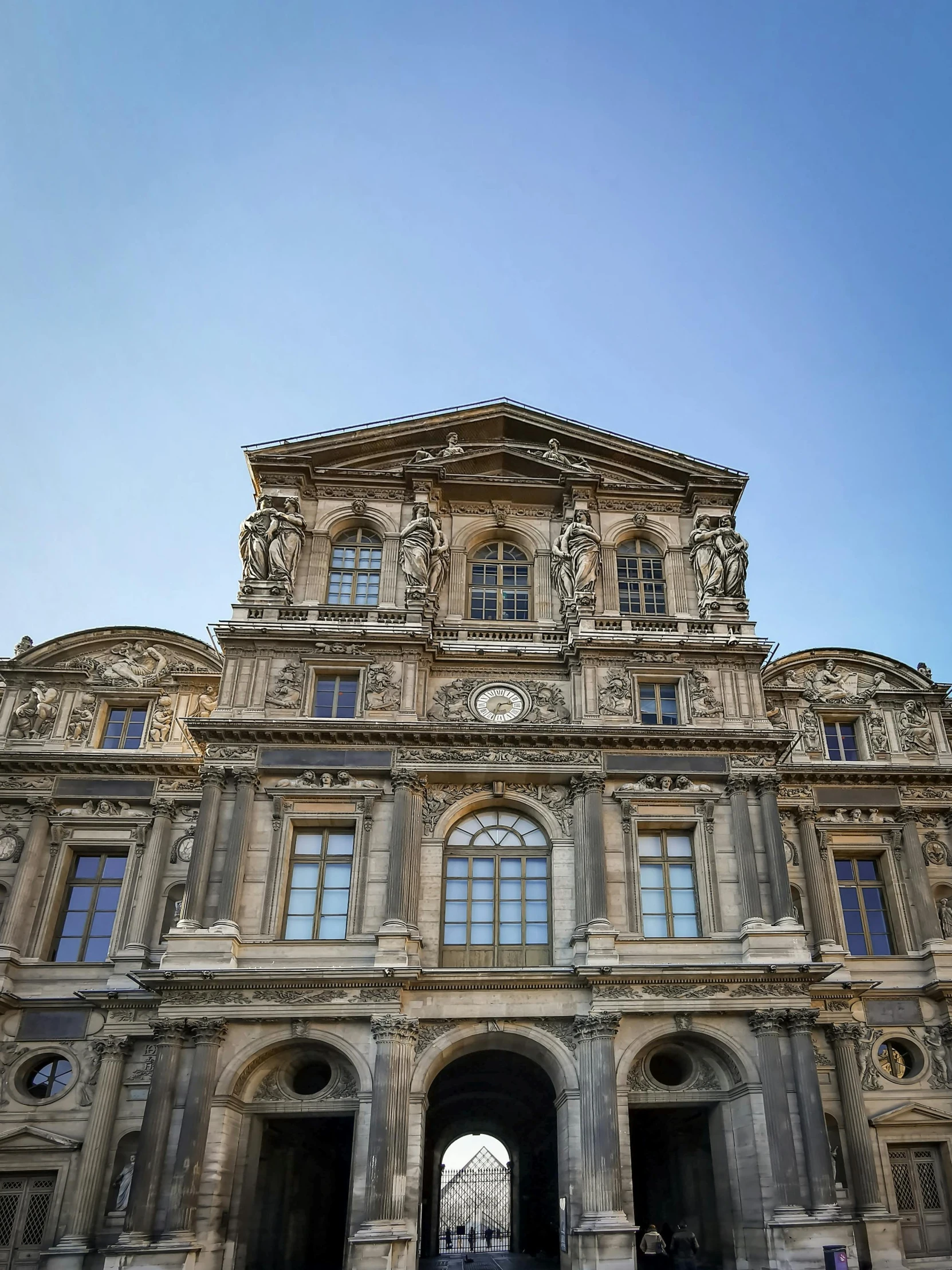 the front of a building with several people walking in it