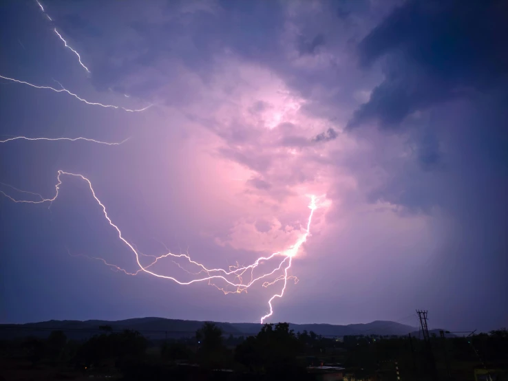 a storm cloud has two lightnings on it and the sky has dark purple clouds