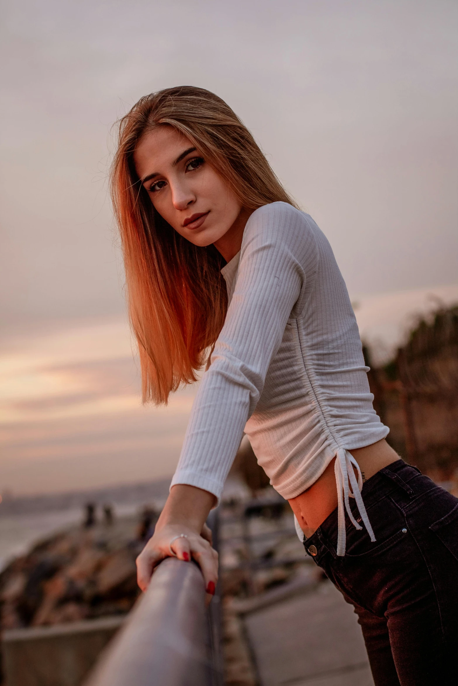 the woman is standing near a railing outside