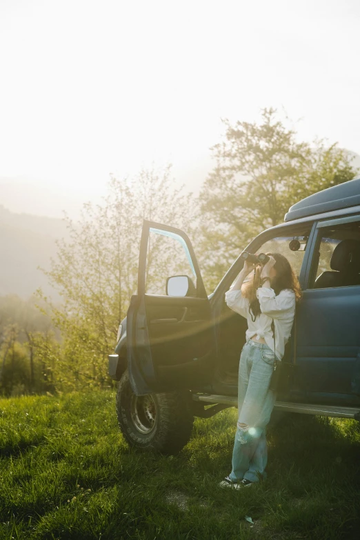 a woman sitting beside the back of a blue truck