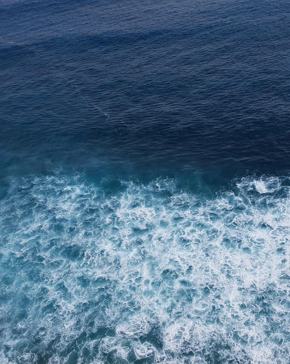 a person is surfing on the water from above