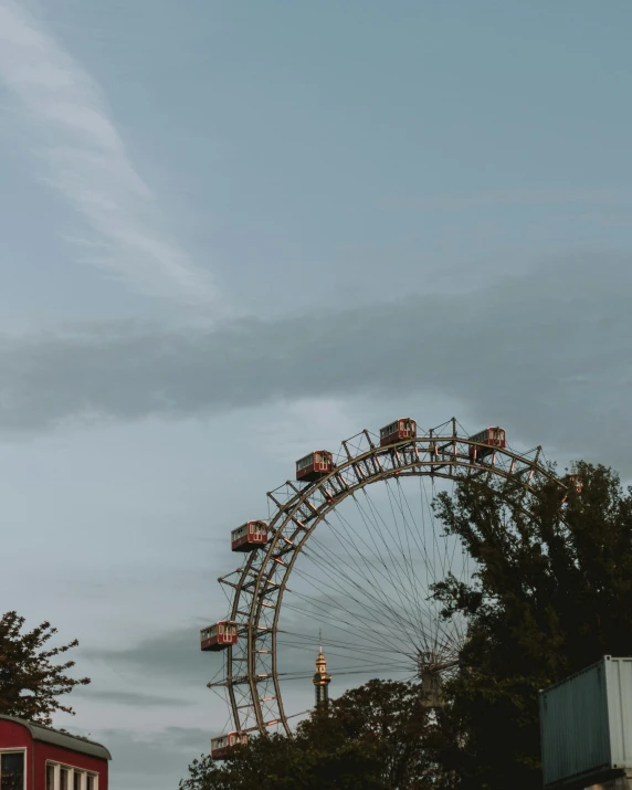 a ferris wheel is located next to buildings on the water