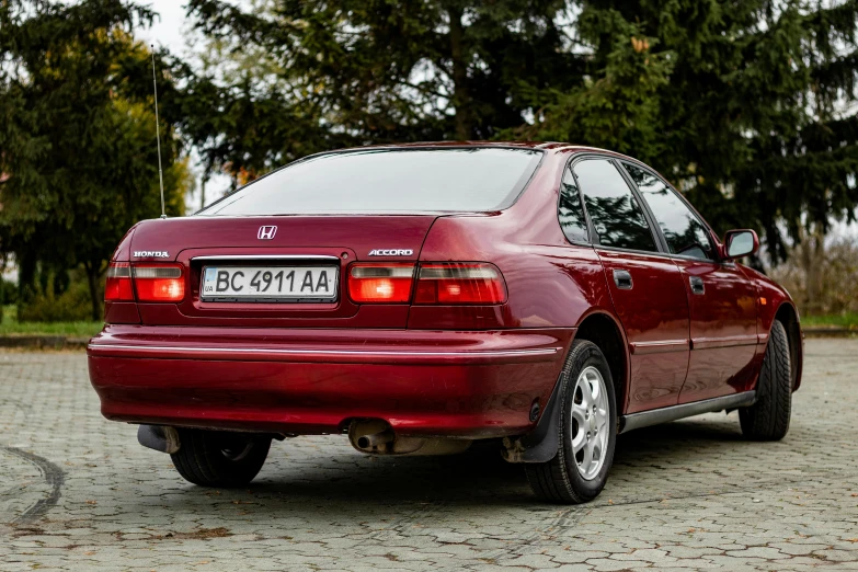 a maroon sedan with no hood and the tail lights turned