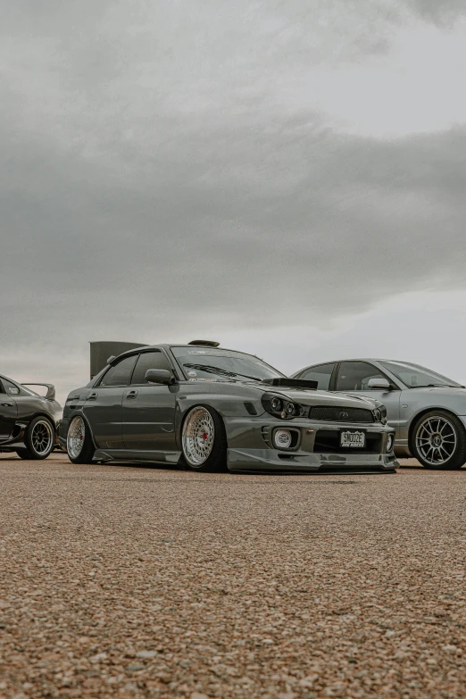 there are two grey cars parked in front of a big building