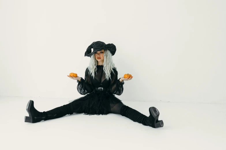 a woman sitting on the floor holding a oranges