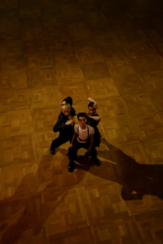 a group of people standing around on a wooden floor
