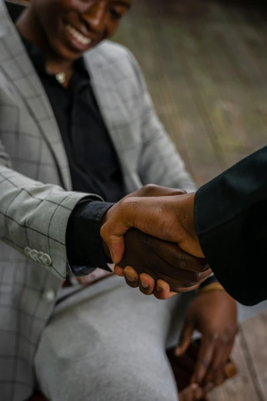 an african american shakes the hand of another african american