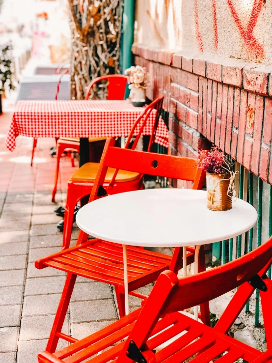 a red table and chairs are set up next to a wall