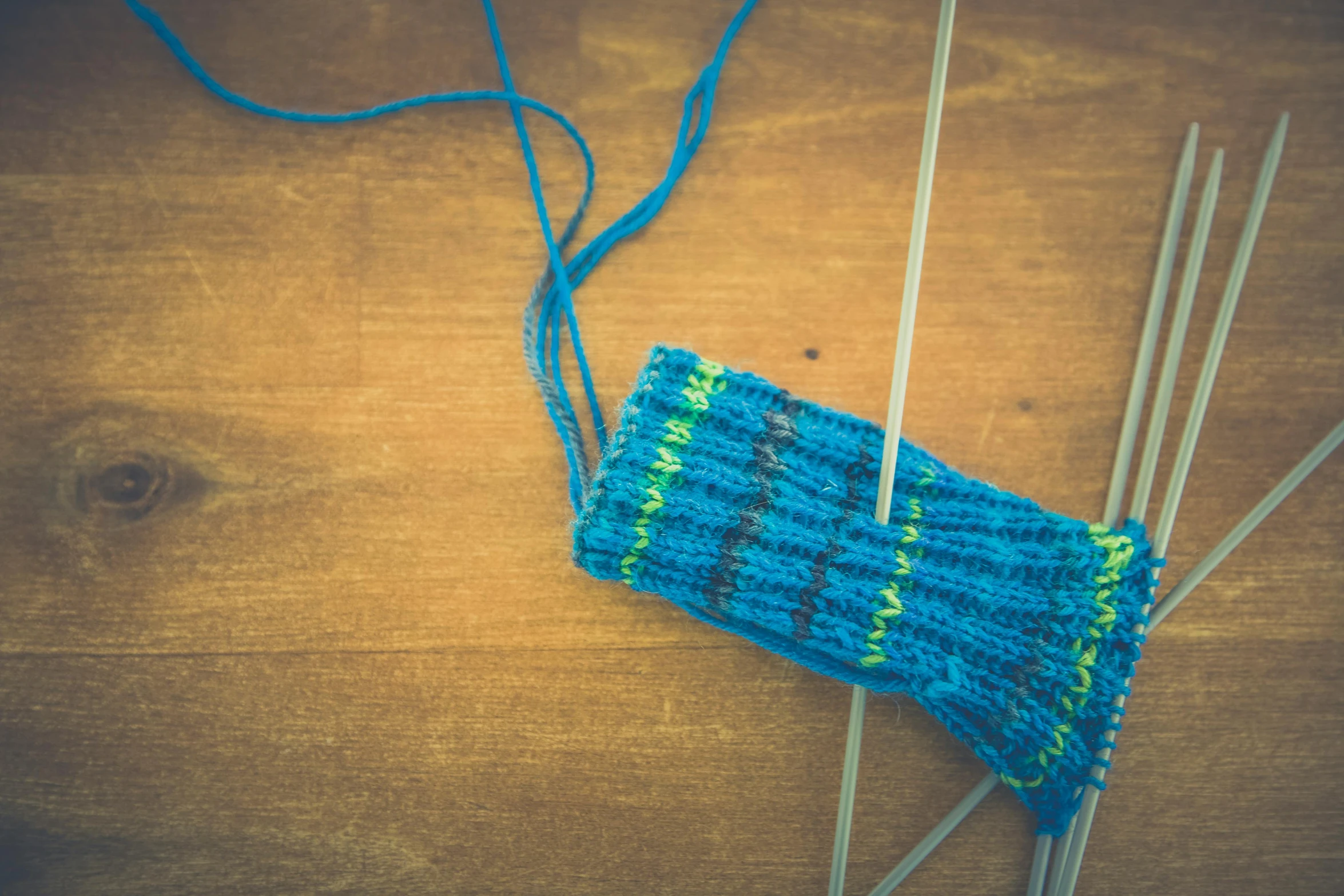 some knitting needles and an odd knitting cloth on a table