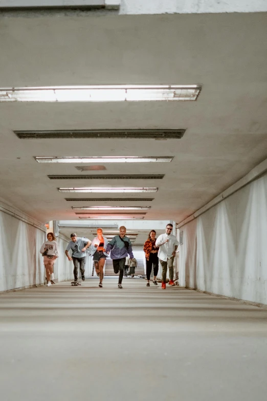 many people are walking down a bridge under an overhead light