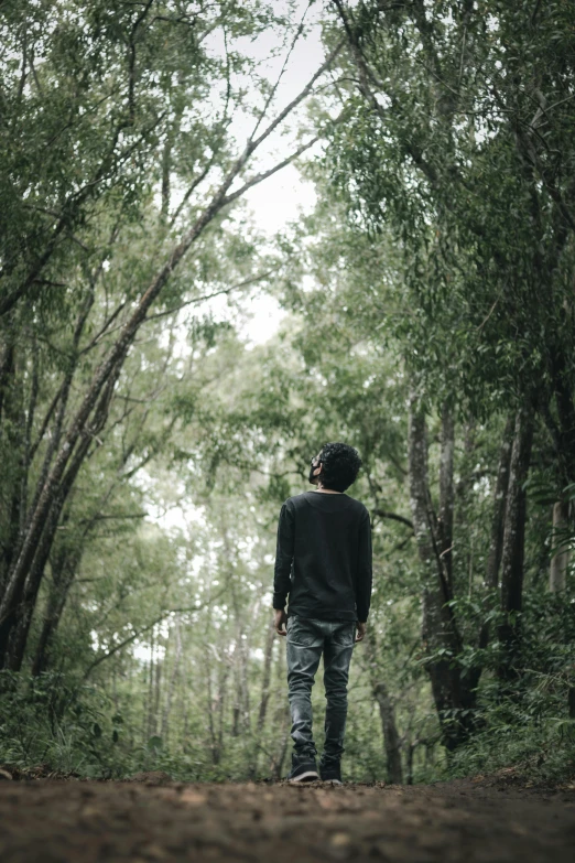 man walking alone in the middle of a dense forest