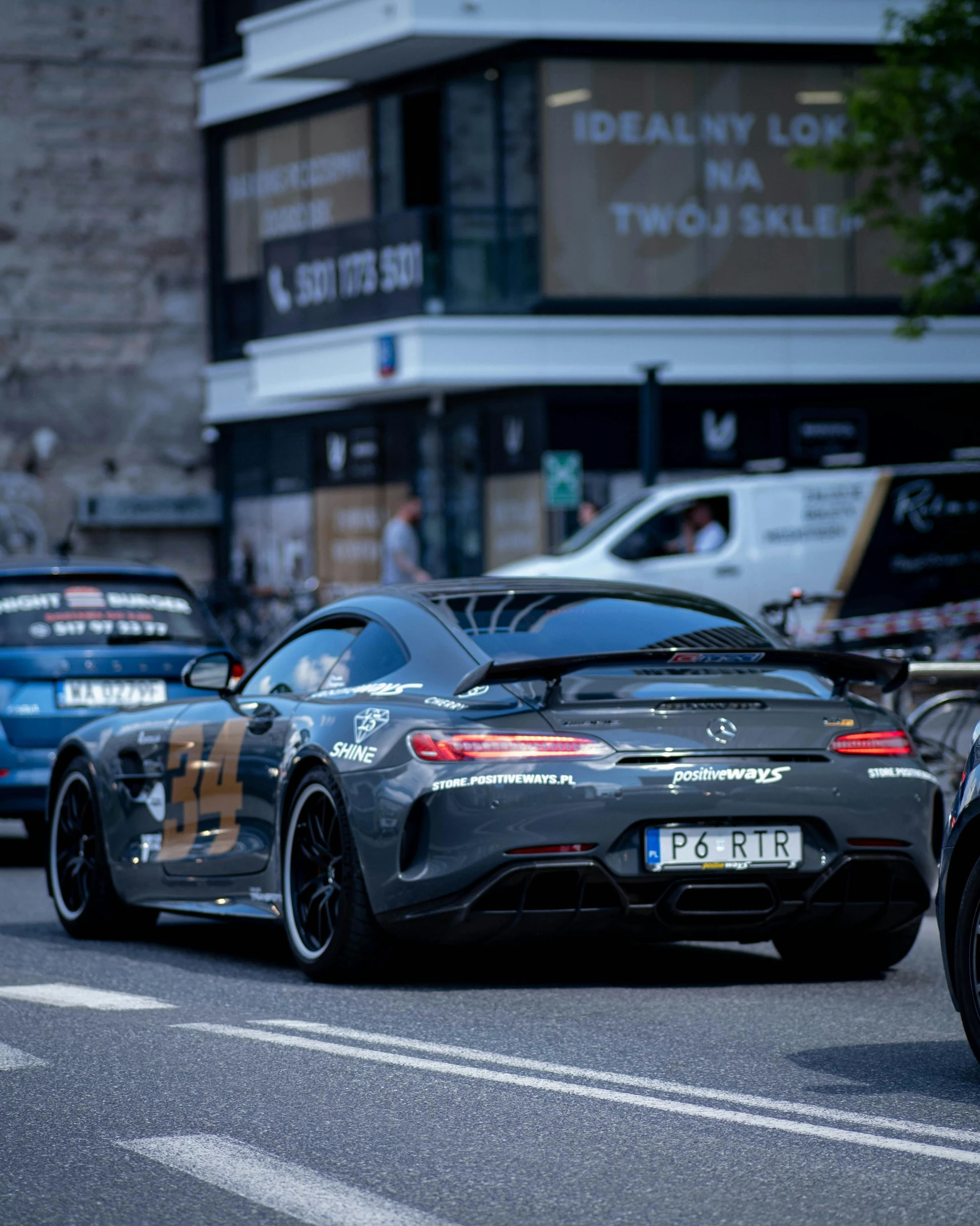 two sports cars driving on a road with other cars around it