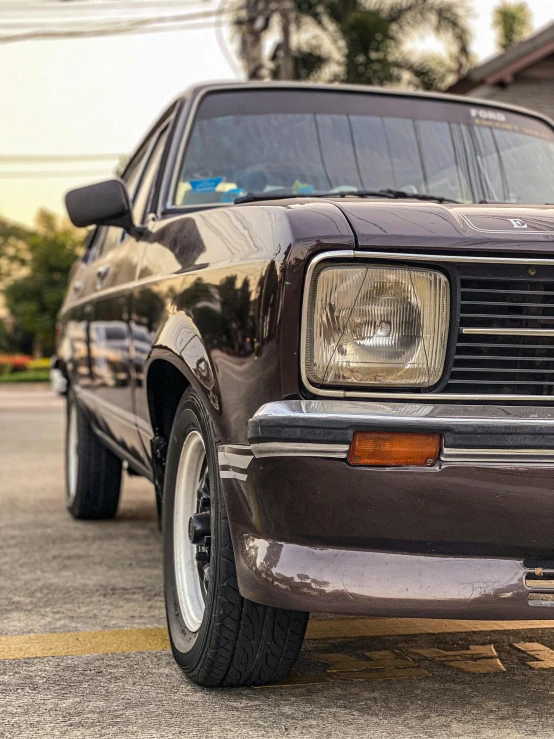 the front of a classic car parked in a lot