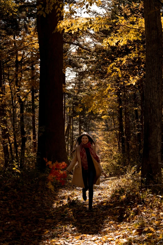 the young woman is walking down the path in the woods