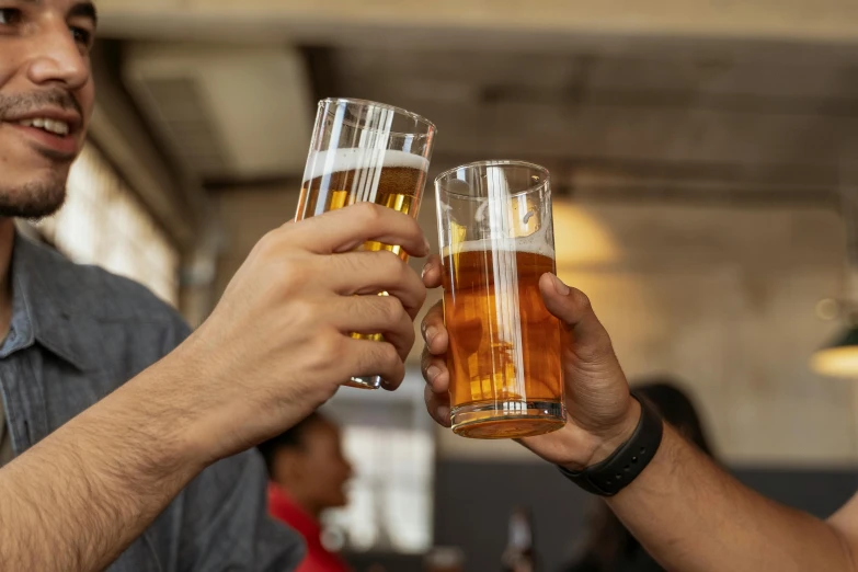 two people toasting beers and smiling at each other