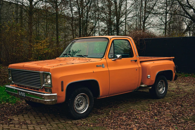 an orange truck parked next to some trees