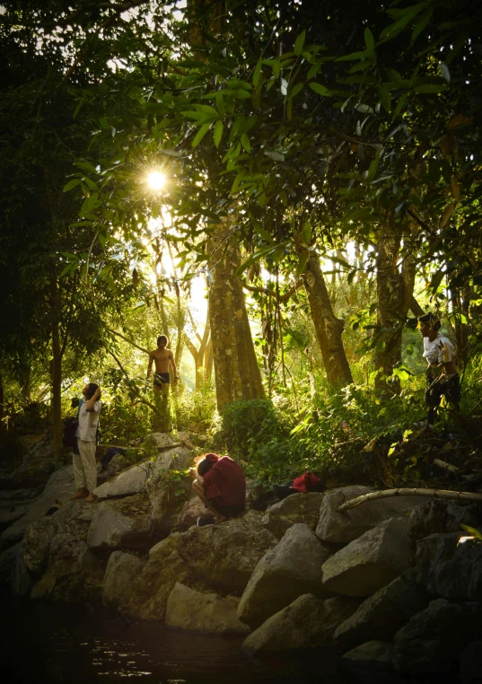 a couple of people are walking across rocks in the woods