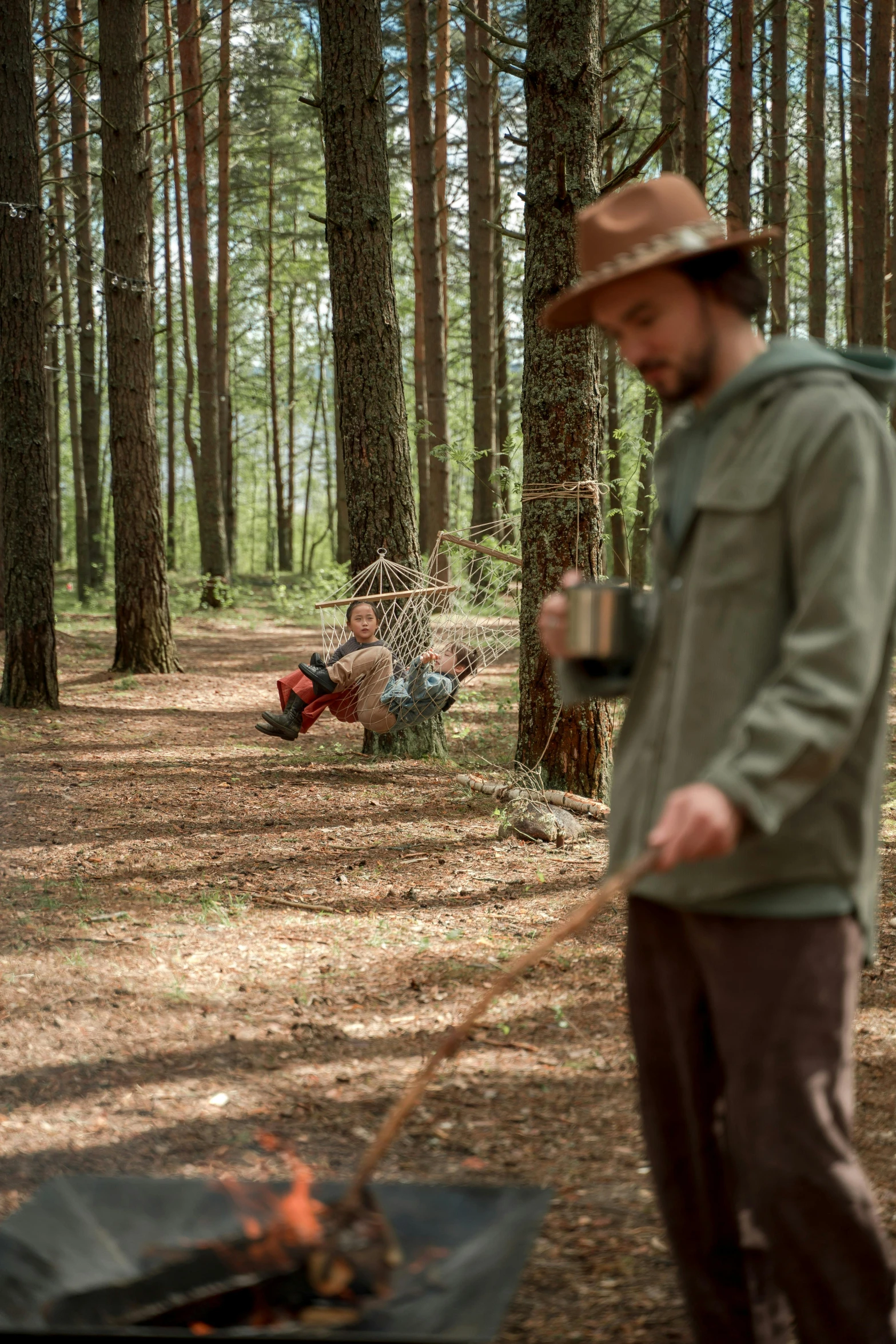 a person standing in the woods near a campfire