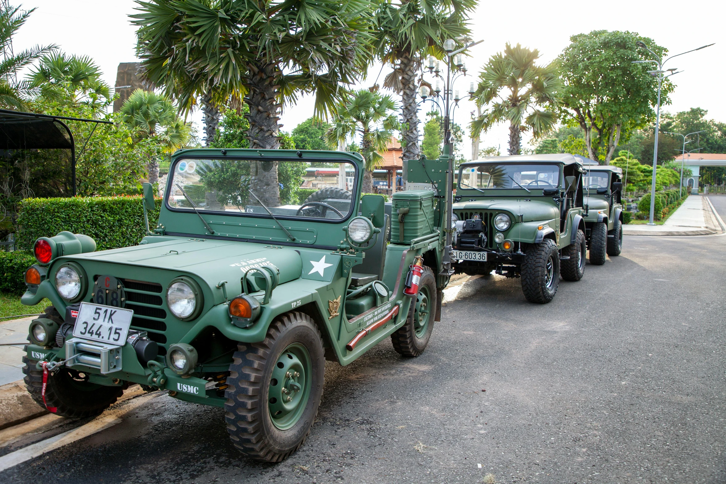 a green jeep and truck parked side by side