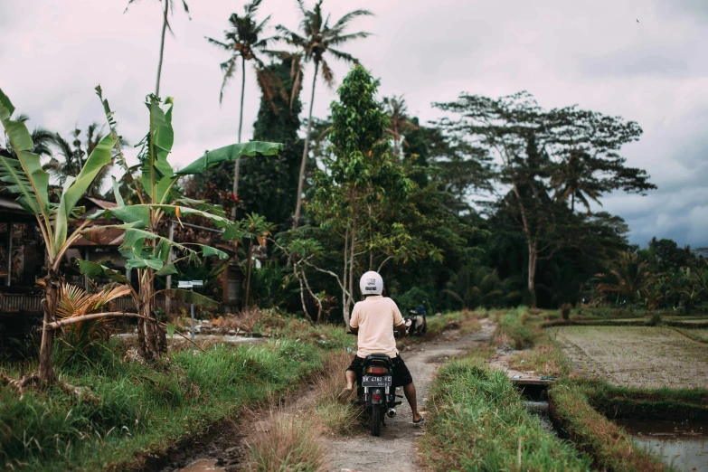 man riding motorcycle along side path in rural area