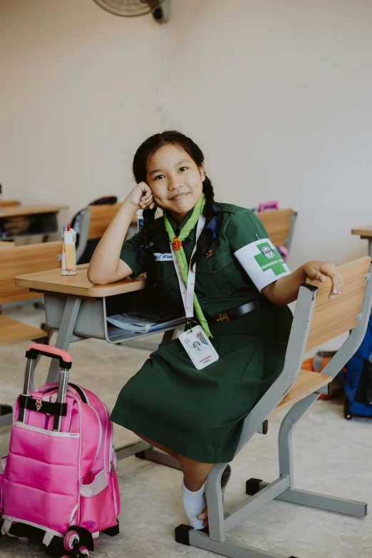 an asian girl sitting at a table with a suitcase