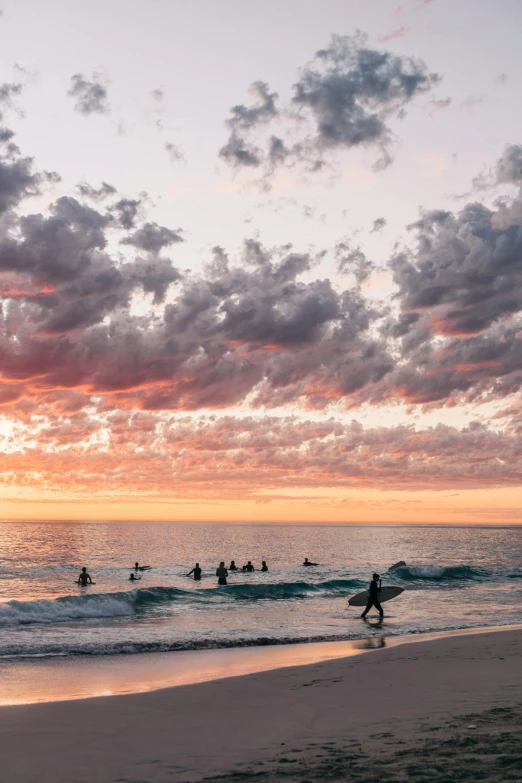 people are playing in the surf on a sandy beach