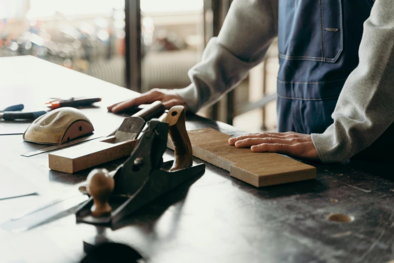 a man with his hands on top of some tools on a table