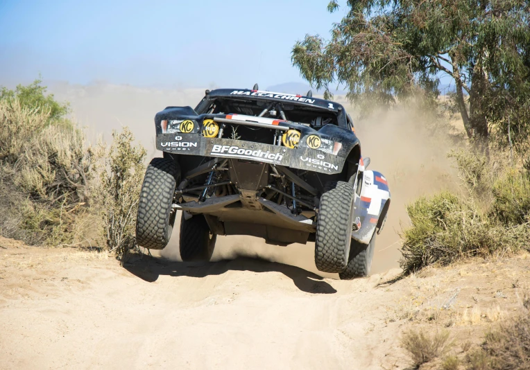 a truck driving down a hill in the desert