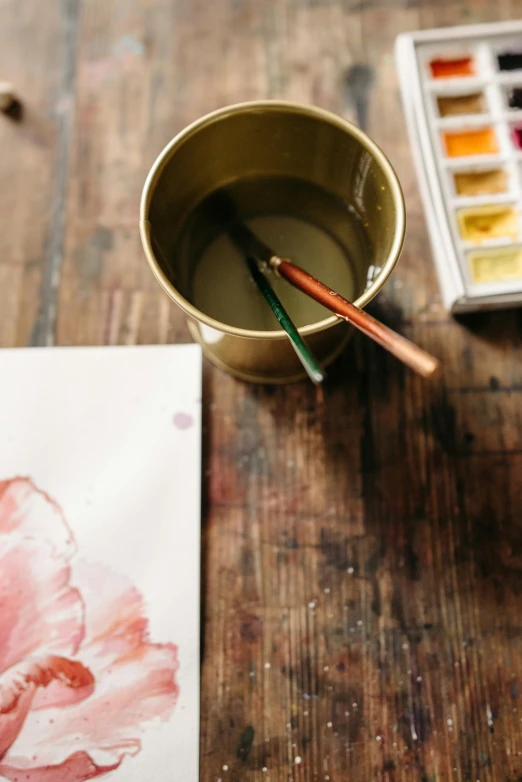 a cup that is sitting on a table with some color and water