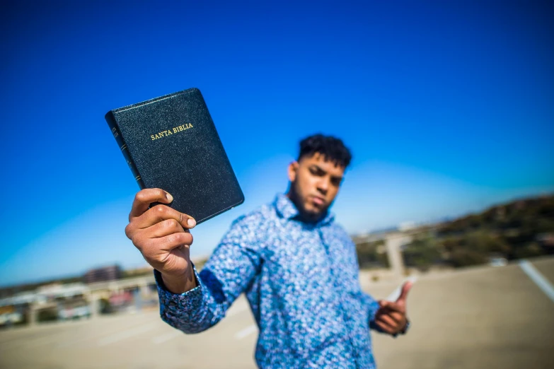 a man in a blue shirt is holding up an empty passport