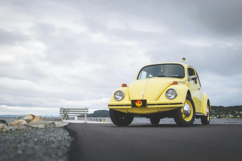 the volkswagen beetle is parked on the side of the road