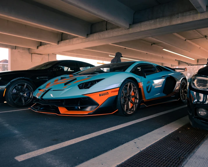 two sports cars parked next to each other under a bridge