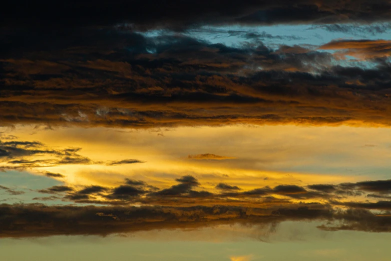 a plane flying in the air with a sky filled with clouds