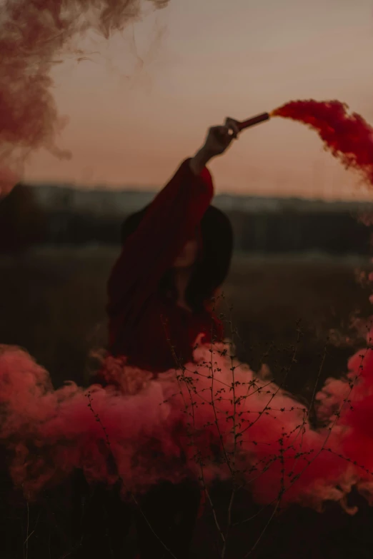 a person with a smokestack in the air in front of red colored smoke