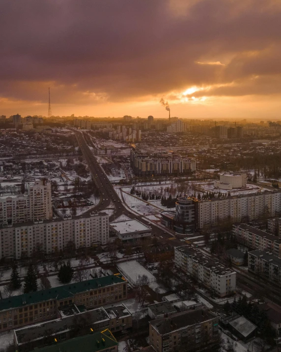 a sunset view over a city, with dark clouds